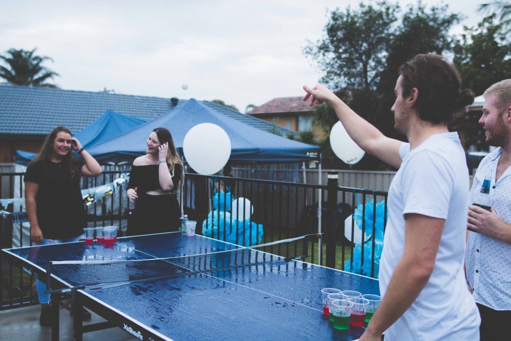 Group of friends playing beer pong on teams
